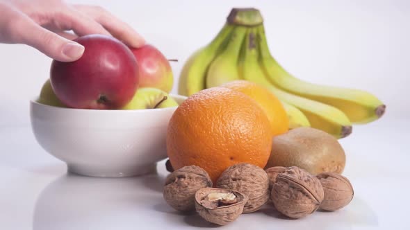 Girl Lays Fruits and Nuts on the Table With Slow Motion