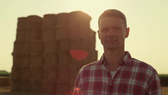 Farmer Posing Hay Bales in Sunlight Portrait