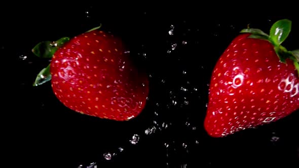 Strawberries Collide and Rotate on Black Background