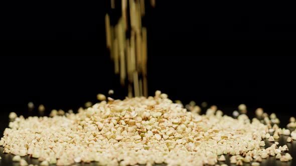 Closeup of Falling Down Green Buckwheat on Glass Table on Black Background