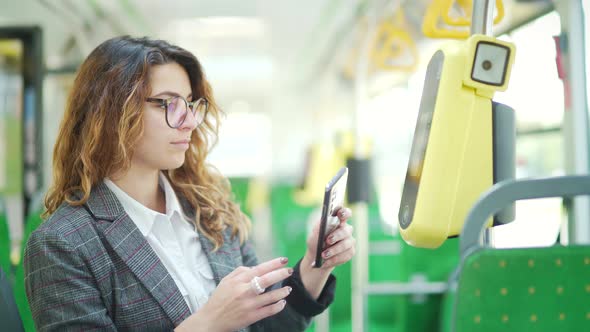 Woman paying public city transport with mobile phone app. 