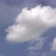 An airplane flies across a blue sky with white fluffy clouds. - VideoHive Item for Sale