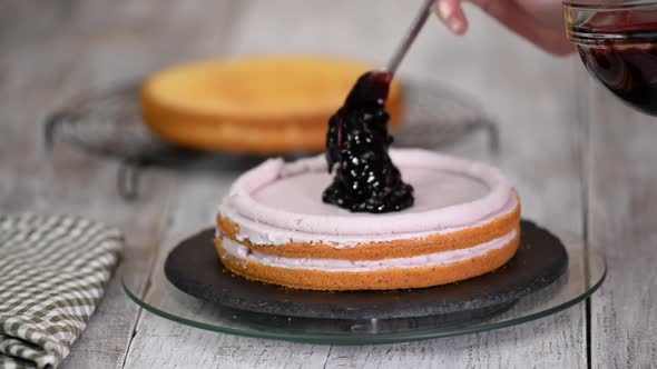 Female Hands Making a Blueberry Jam Cake 