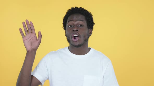 African Man Waving Hand to Welcome Yellow Background