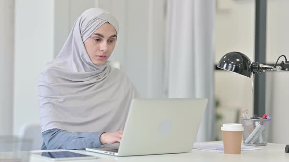 Young Arab Woman Working on Laptop in Office