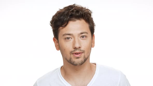 Young Handsome Man Smiling Winking Looking at Camera Over White Background