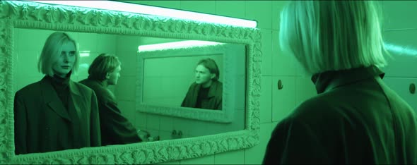 Woman and Man Looking in Mirrors in Bathroom with Green Light