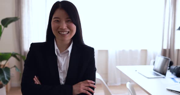 Asian young woman smiling on camera inside modern office