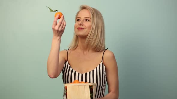 Beautiful woman with orange on blue background