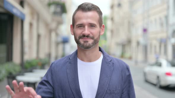 Outdoor Portrait of Positive Man Showing OK Sign