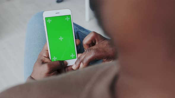 Greenscreen or Mock-up Tracking in African American Male Hands. Using Smartphone at Home, Sharing