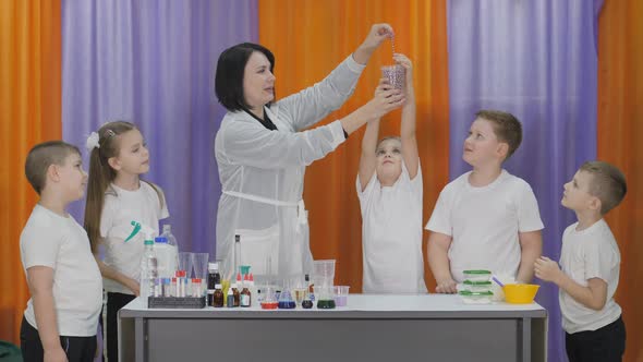 Chemical Experiments for Children. Child Pulls the Beads Out of the Glass, and They Begin To Fall