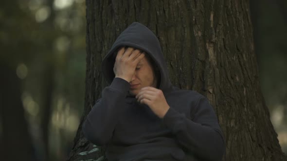 Depressed Man Sitting Under Tree in Park, Unemployment Problem, Difficulties