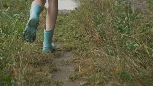 Close-up of Running Legs Stepping on Small Rain Puddle