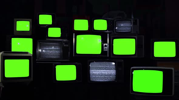 Fifteen Retro TVs turning on Green Screens with Static. Blue Dark Tone.