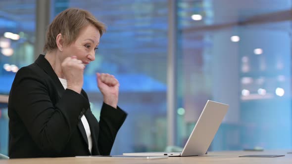 Old Businesswoman Celebrating Success While Working on Laptop