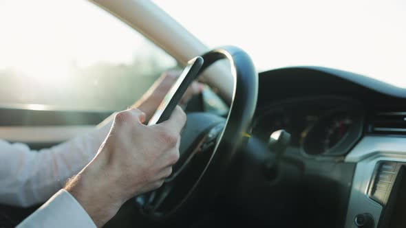 Close-up Hands of Unrecognizable Man Typing Online Message Using Mobile Phone While Sitting at Car