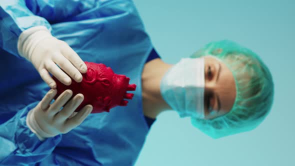 Young Caucasian Surgeon Holding a 3d Artifficial Heart Model and Showing It to the Camera