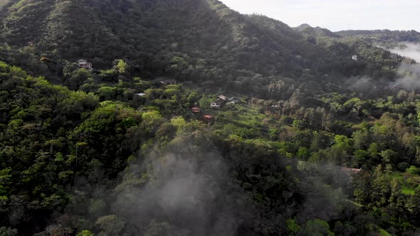Low clouds over homes in Valle de Anton in central Panama extinct volcano crater valley, Aerial doll