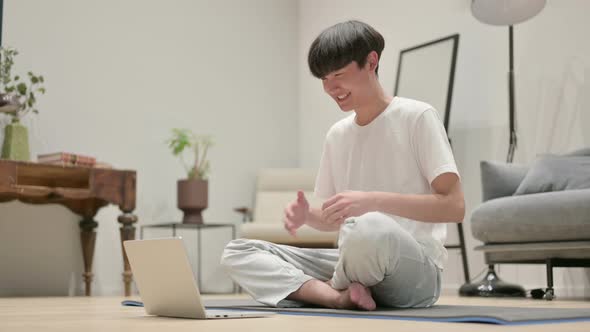 Young Asian Man Using Laptop on Yoga Mat at Home