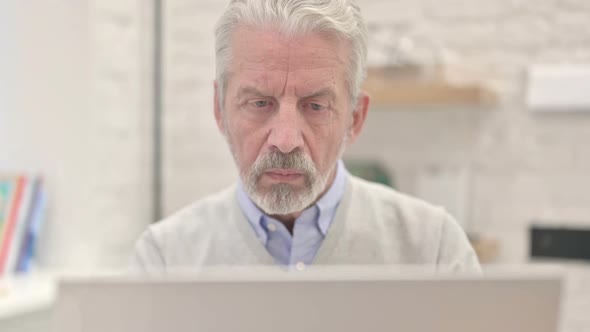 Close Up of Thinking Old Man Working on Laptop