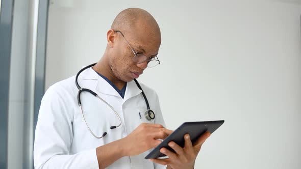 Young Afro American Male Doctor Doctor Making Notes in Tablet