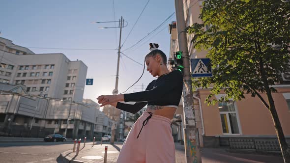 Young Woman Shows Moves of Hiphop Dance at Back Sunset