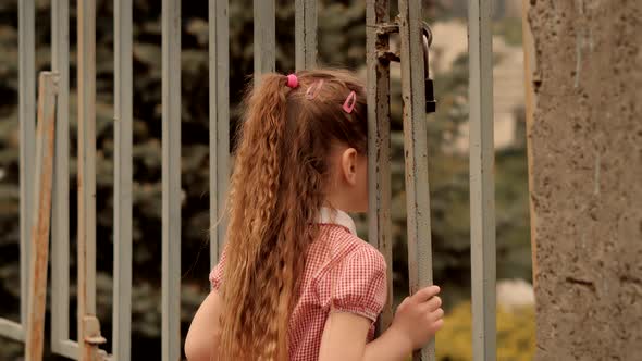 Family Having Fun In Park. Little Girl Looking Through Fence Grate On City Panorama.