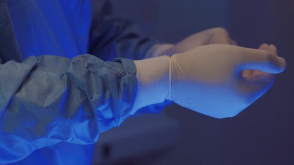 Doctor's Hands Putting Off Surgical Gloves After Operation or Examination