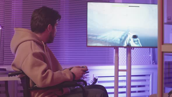 Man in Wheelchair Playing FPS Game with Controller