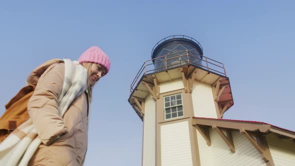 Low Angle Shot of Attractive Woman Walking Around Lighthouse Tower at Sunrise 6K