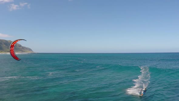 Aerial view of a man kitesurfing in Hawaii.