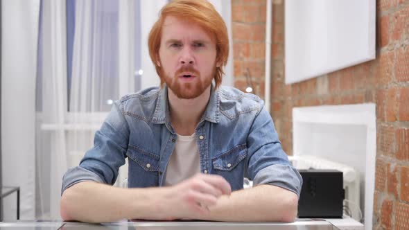 Portrait of Redhead Beard Man Pointing at Camera in Office