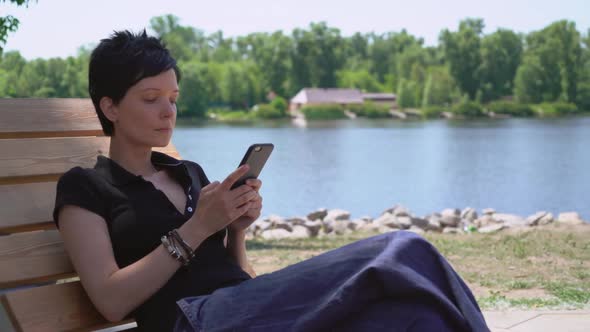 Female Typing Sms on Mobile Outdoors