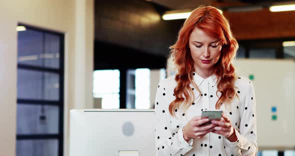 Businesswoman text messaging on mobile phone