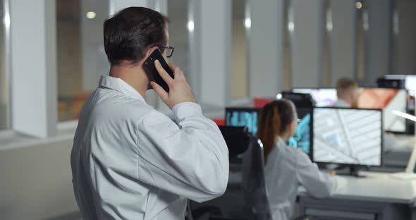 Side View of Technician Talking on Smartphone in Lab