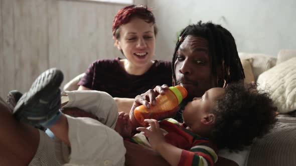 Cute Little Boy Drinking Juice From Feeding Bottle alt