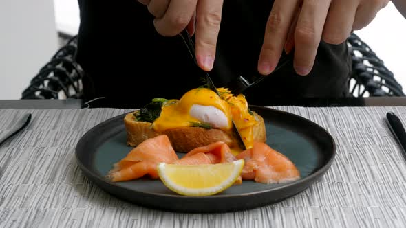 Eggs Benedict with Bread Spinach and Salmon with Lemon on Black Plate