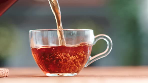 Closeup Pouring Fresh Hot Black Tea Into Cup From Teapot Serving Kitchen Table Summer Breakfast