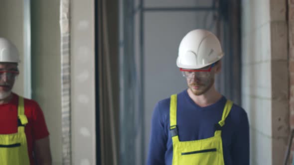 Happy Construction Workers Smiling and Talking In New Building