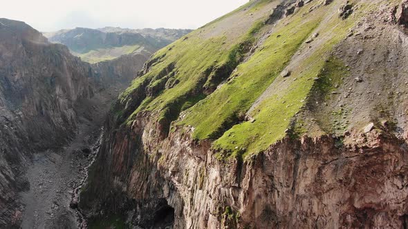 Big Brown Sharp Cliffs with Grass on Top and River in Canyon