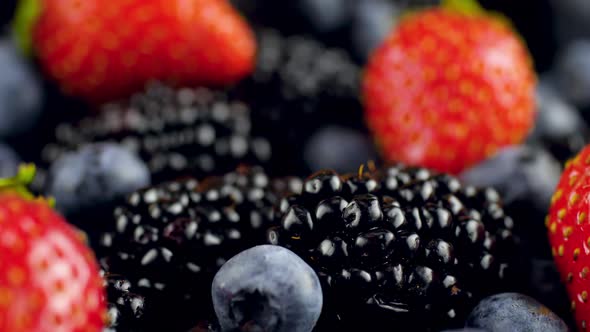 Macro  Video of Camera Sliding Over Lots of Blackberry Strawberry and Blueberry Lying on Desk