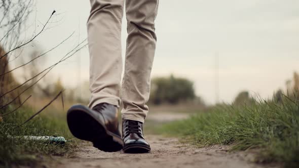 Confidence Man Feet Walking On Grass Field. Guy Rest On Holiday. Man Legs Walking On Park.