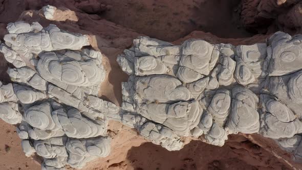 Top down ascending drone shot over a very unique rock cliff formation in the Southern Utah desert