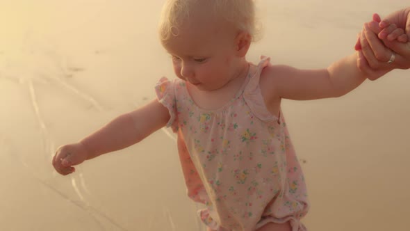 Father or Mother and Baby Toddler Child Daughter Girl Kid Foot Walking on Beach Leaving Footprint in