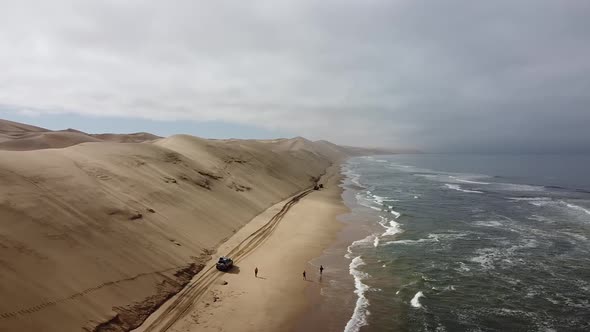 Aerial shot of the Sandwich Harbour massive sand dunes on the shore of the ocean