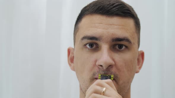 Young Man Is Shaving His Face Cleanly Electric Razor