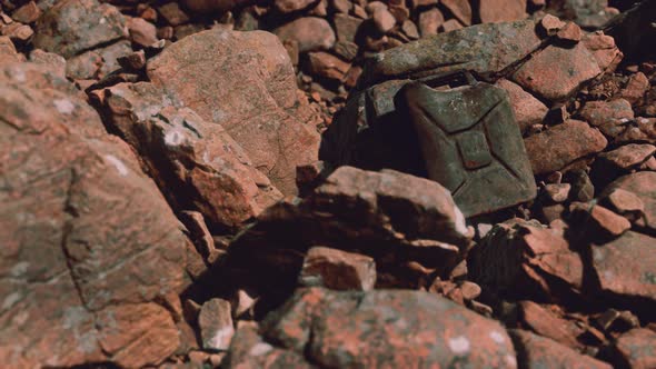 Old Rusty Metal Canister for Gasoline Fuel at Rocks