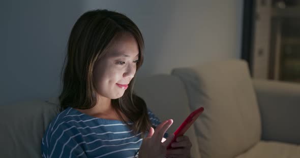 Woman use of cellphone at home in the evening