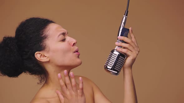 Beauty Portrait of Young African American Woman Singing Song Into Vintage Retro Microphone